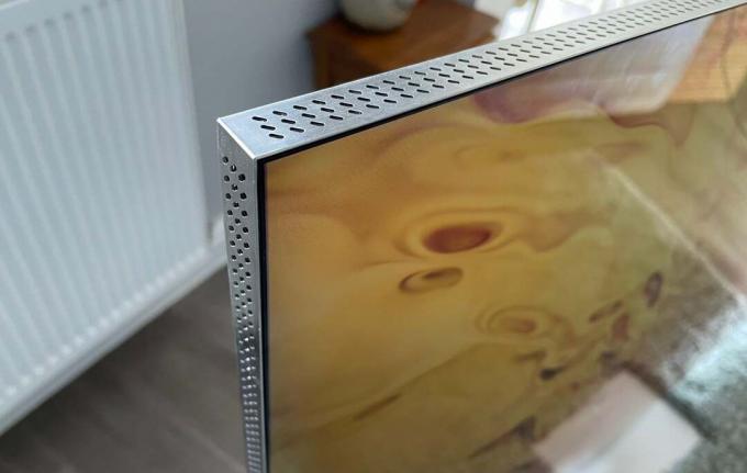 Eckdetail des Samsung QE75QN900B mit gegrillter Oberfläche zur Aufnahme der eingebauten Lautsprecher des Fernsehers.