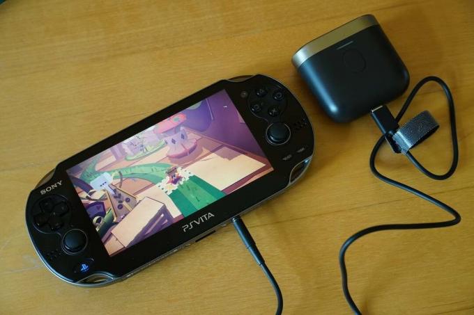 سوني بلاي ستيشن PS Vita أسود يعرض لعبة مع أدوات تحكم للألعاب على كلا الجانبين ، جاك متصل به وطرف آخر متصل بمكبر صوت ، يعرض صوت Bowers و Wilkins P17 الانتقال