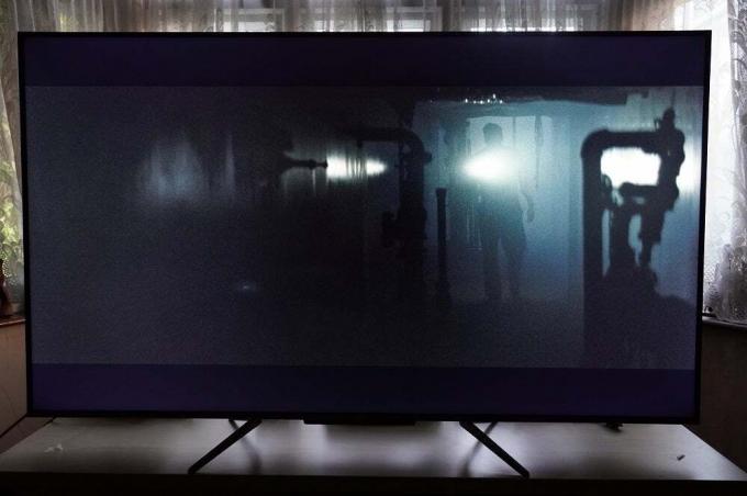 Μια μαύρη τηλεόραση TCL-55C715K που στέκεται σε ένα τραπέζι, εμφανίζοντας μια σκηνή από το Bad Times Royale