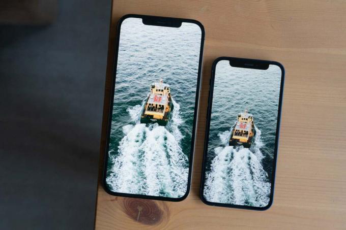 Dva iPhony položené na stole zvisle zarovnané, pohľad zhora, na oboch je zobrazený obraz lode vo vode